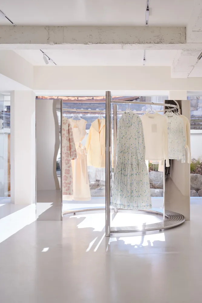 Minimalist retail storefront featuring metal racks with clothing