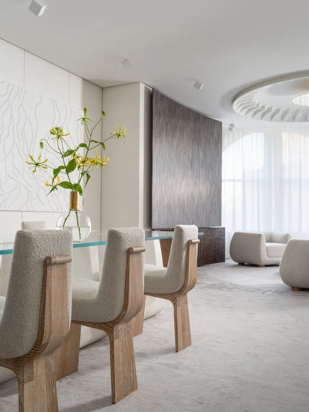 Modern dining room with wood, cloth, glass, and metal elements, featuring a dining table and chairs.