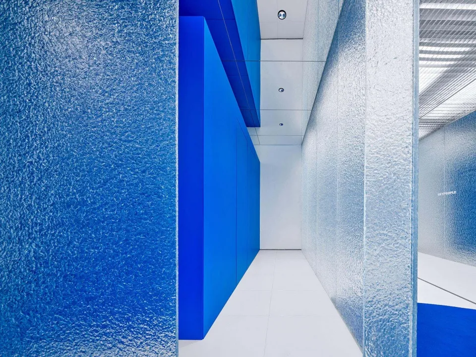 A minimalist interior space featuring metallic surfaces and glass panels.