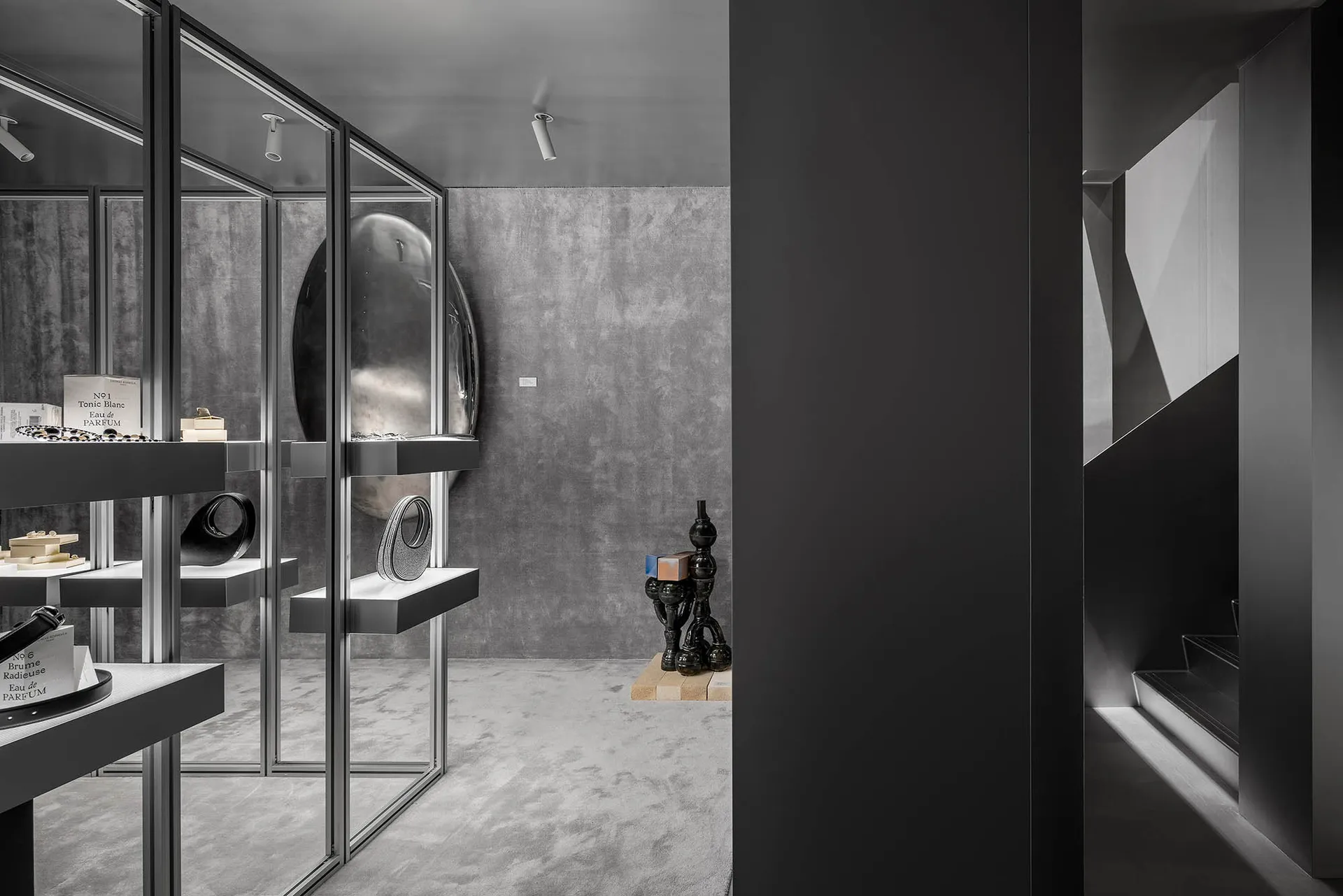 Modern, minimalistic retail store display featuring glass and concrete materials.