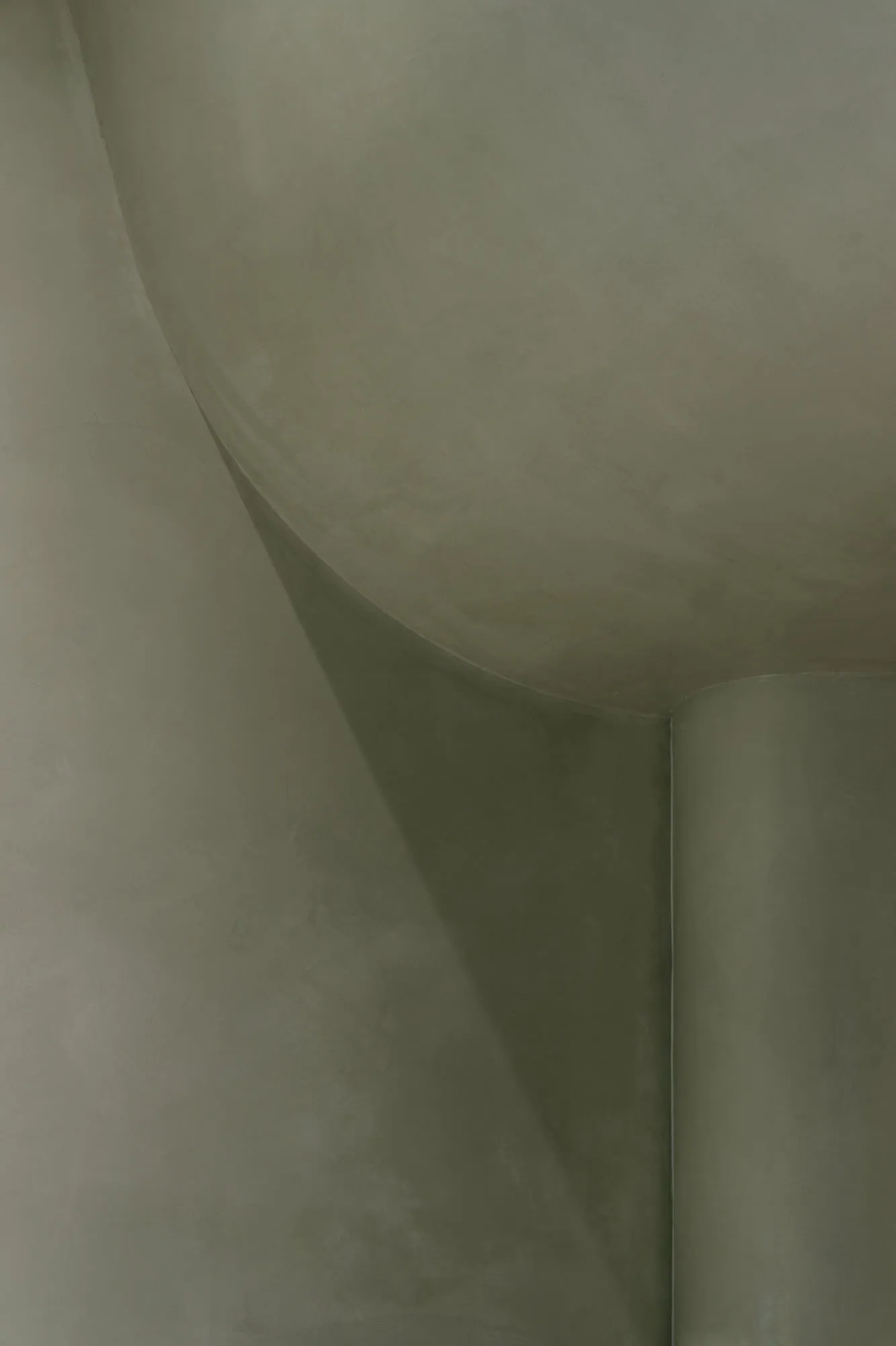 A close-up image of a curved concrete surface with a smooth texture, highlighting architectural details.