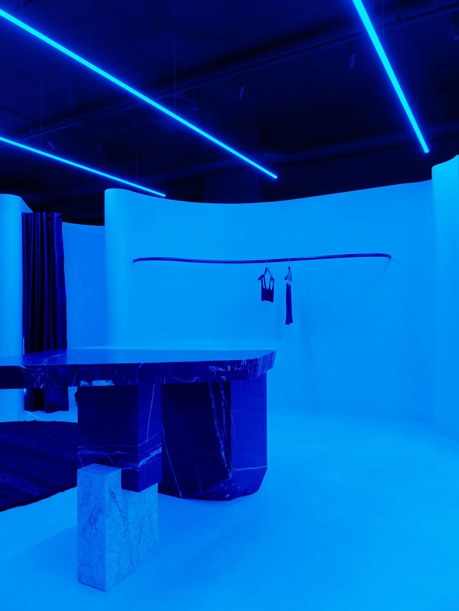 Modern interior with marble furniture and bright blue lighting