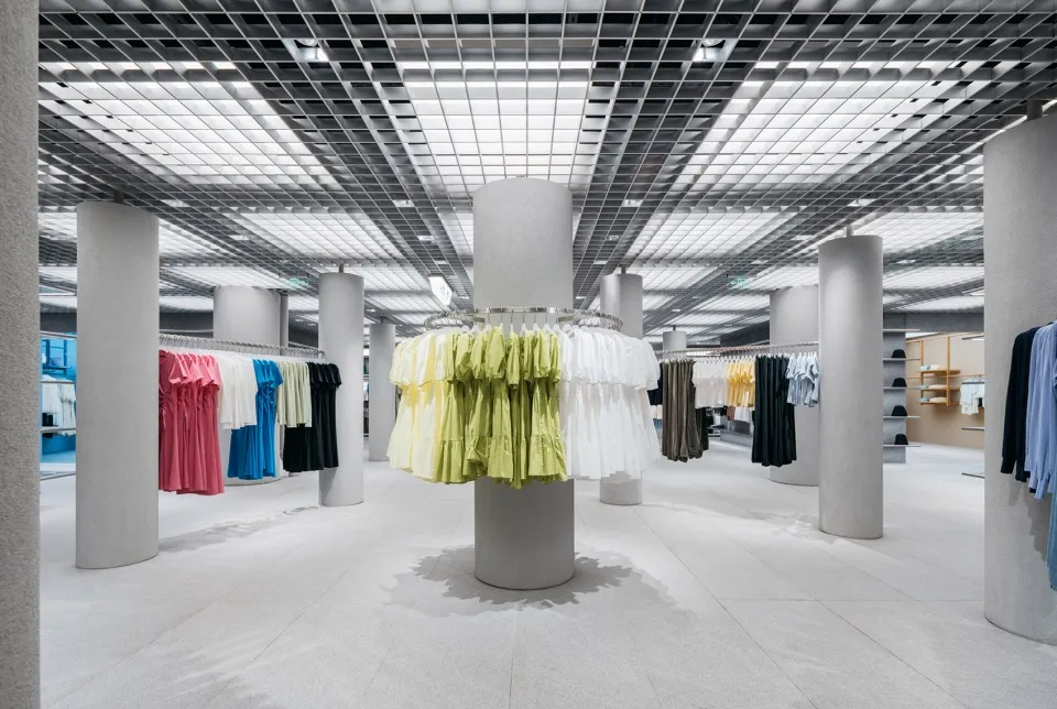 現代服裝零售店室內,搭配混凝土柱與玻璃燈具。