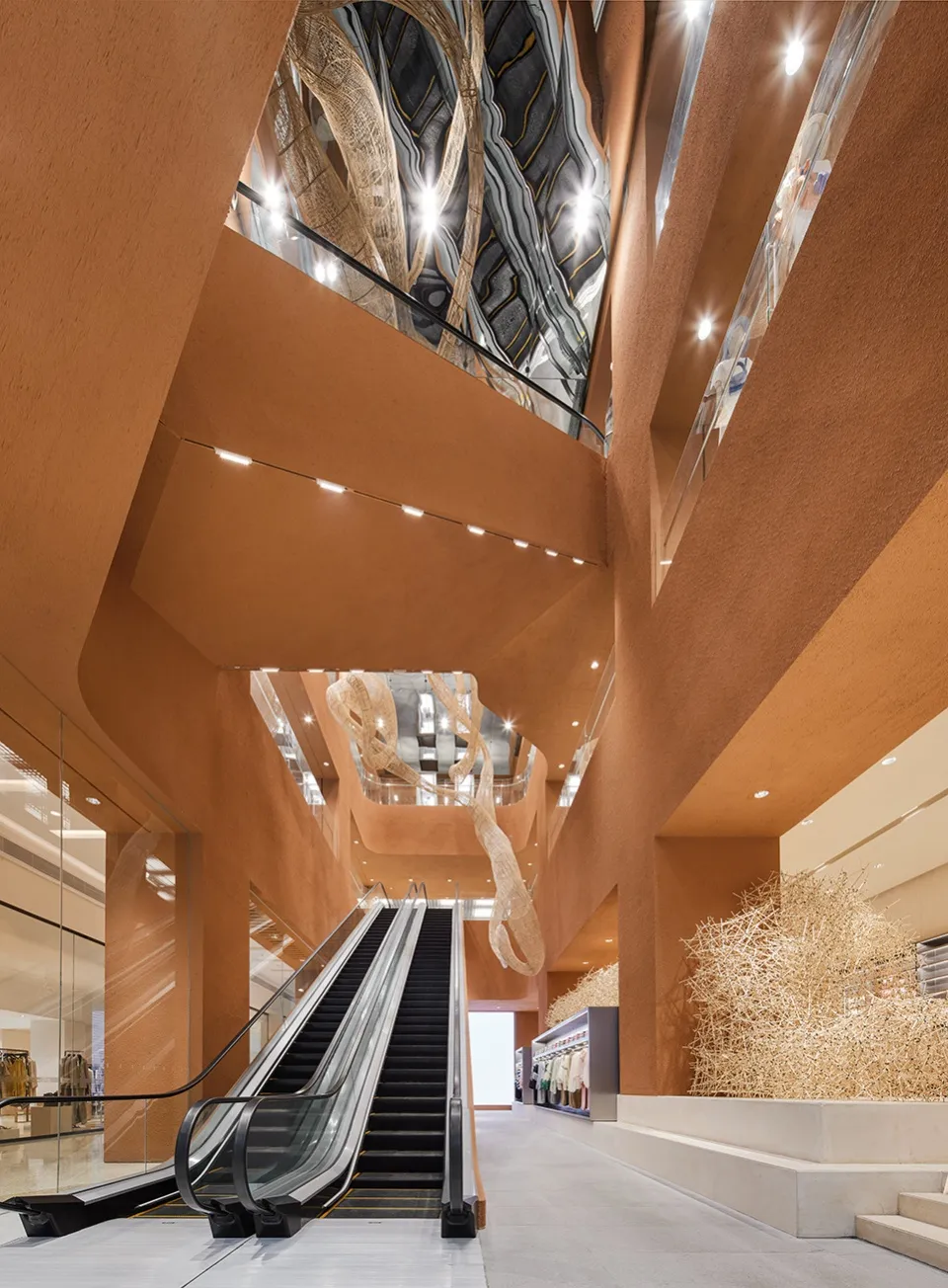 現代購物中心內的混凝土與玻璃材質電扶梯。