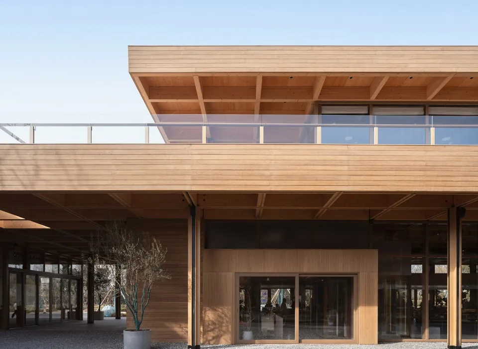 Modern architectural exterior with wooden facade and large glass windows.