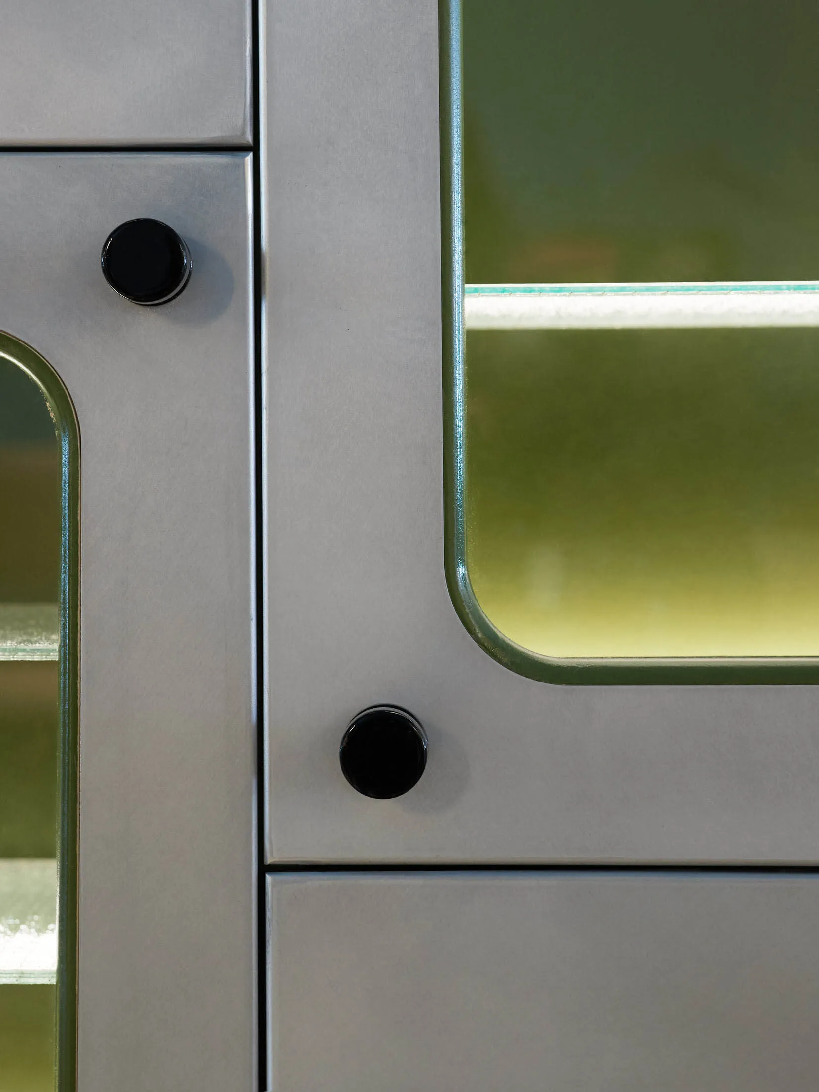 Modern metallic interior fixture with round knobs and frosted glass panel.