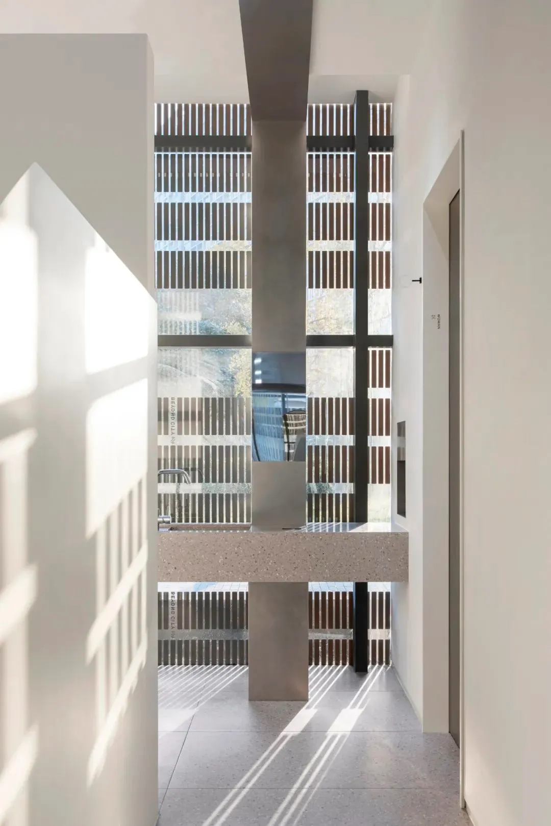 Modern corridor with concrete walls, floors, and columns.