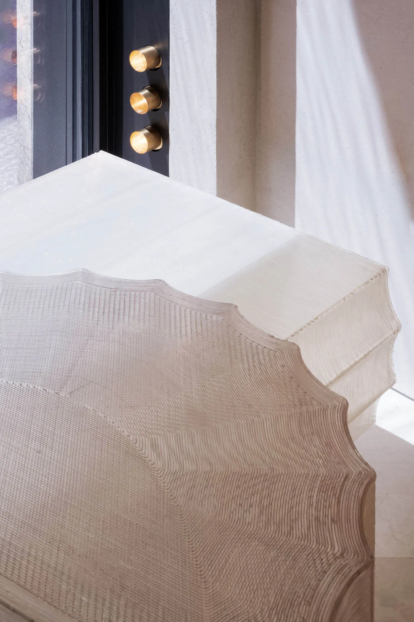 A modern bedroom with a textured, neutral-colored bedspread on a white platform bed.