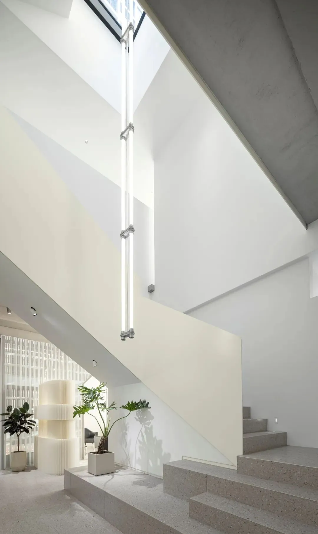Modern, minimalist staircase with concrete steps and integrated lighting in a clean, white interior space.