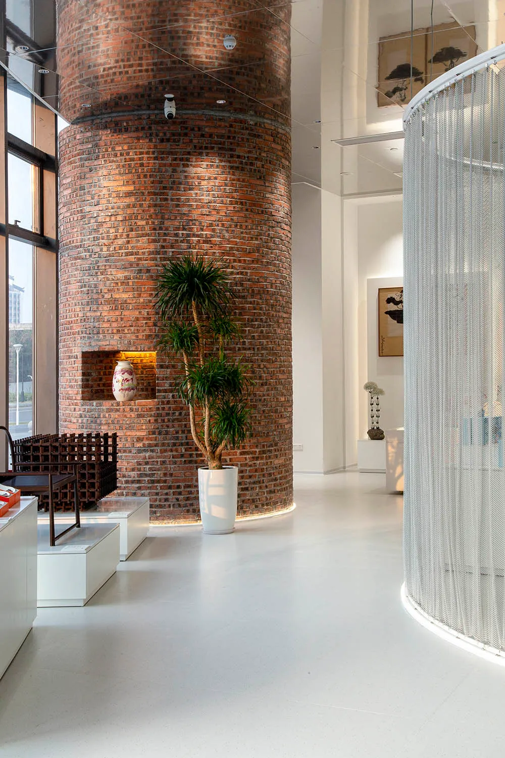 A modern industrial office featuring a large brick column and minimalist design elements.