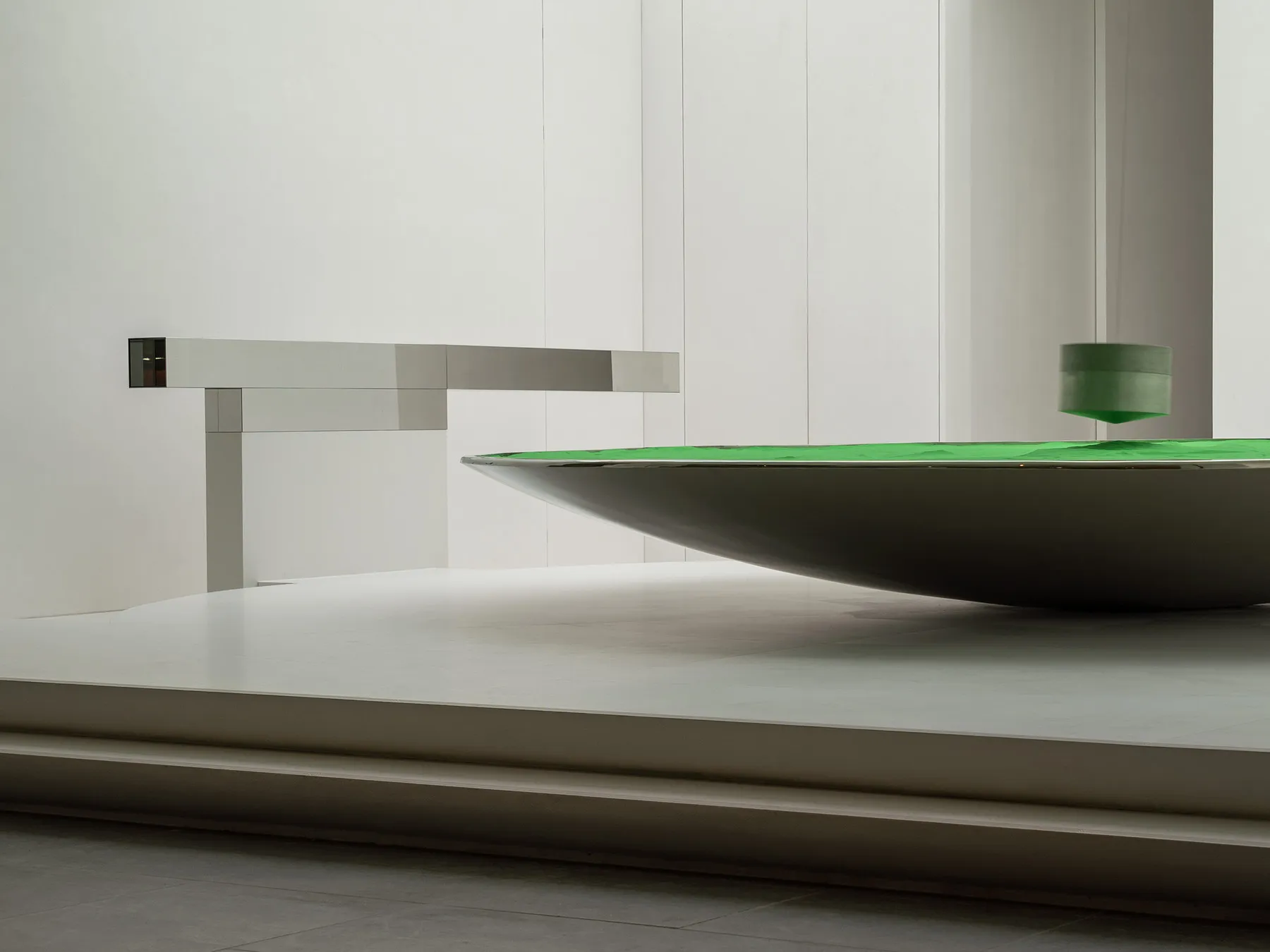 A modern interior design featuring a metallic table with a green surface.