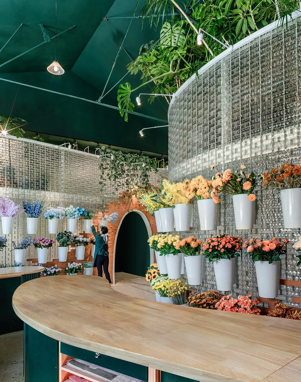 A modern restaurant interior with wooden tables and greenery