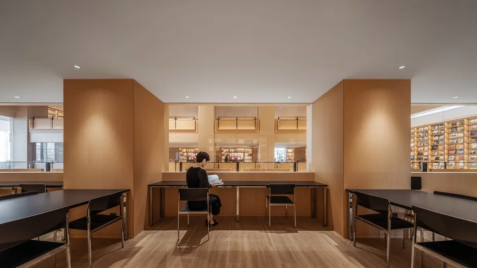 A serene library interior with wooden shelves and tables.