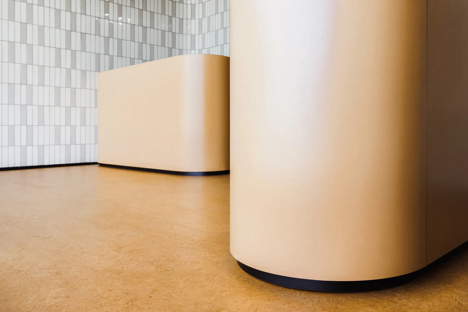 A minimalist reception desk with a smooth beige finish.