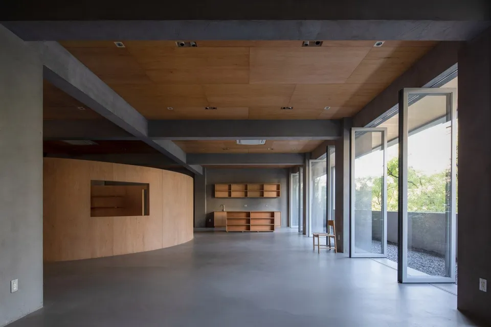 Modern living space with wooden furniture and concrete walls.