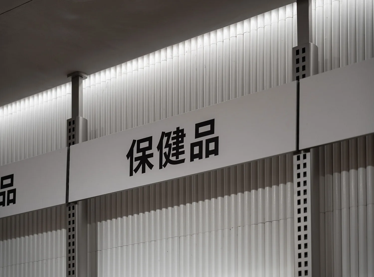 A metallic retail storefront sign with bold Chinese characters.