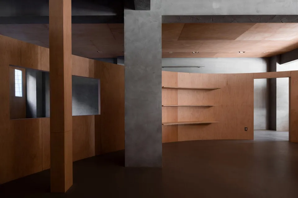 Interior design of a minimalist living space featuring concrete, wood, and metal materials.