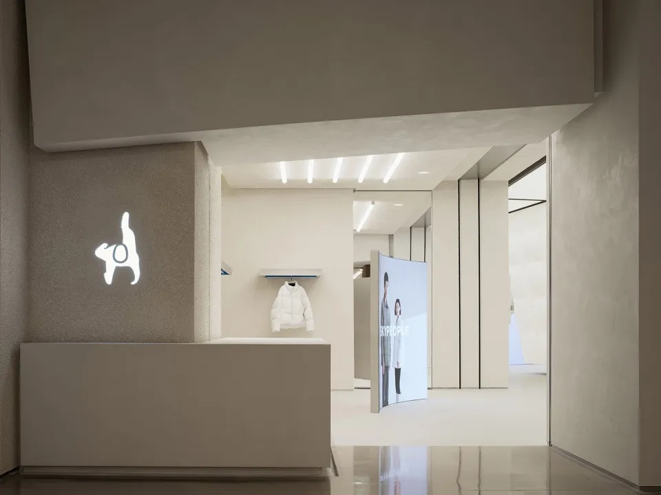 A minimalist retail storefront featuring concrete walls and a sleek, modern design.