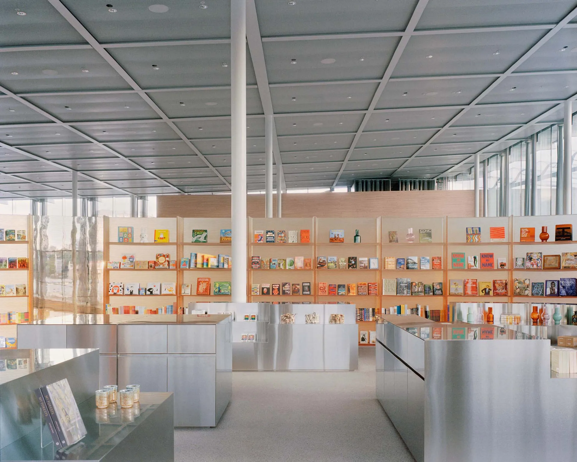 A modern bookstore with metal shelves displaying various books and products.