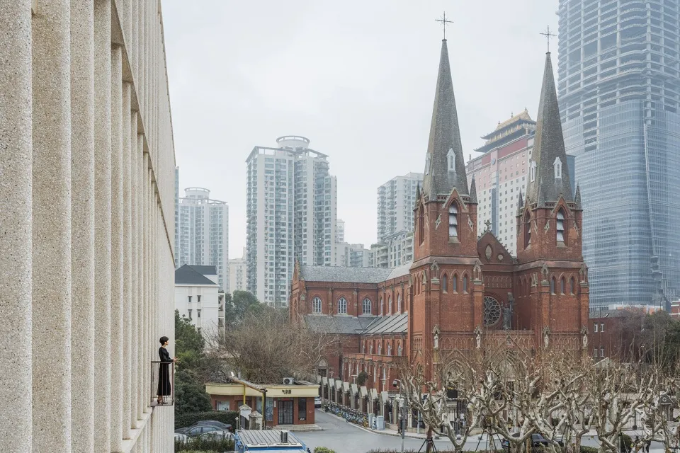 A photograph depicting an urban church with modern skyscrapers in the background.