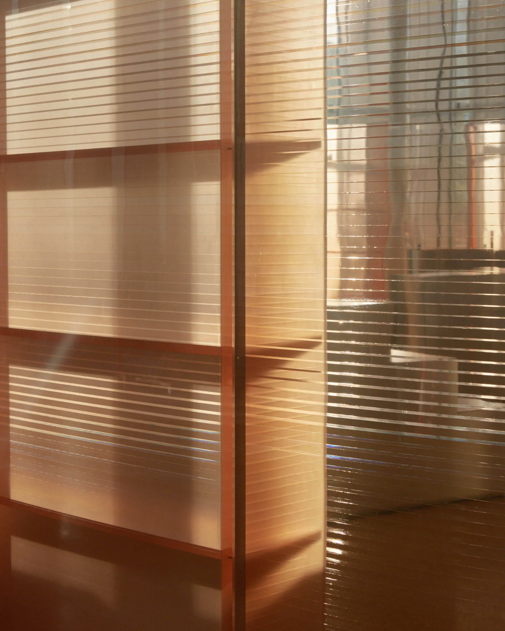 Modern interior with glass panels and a storage unit.