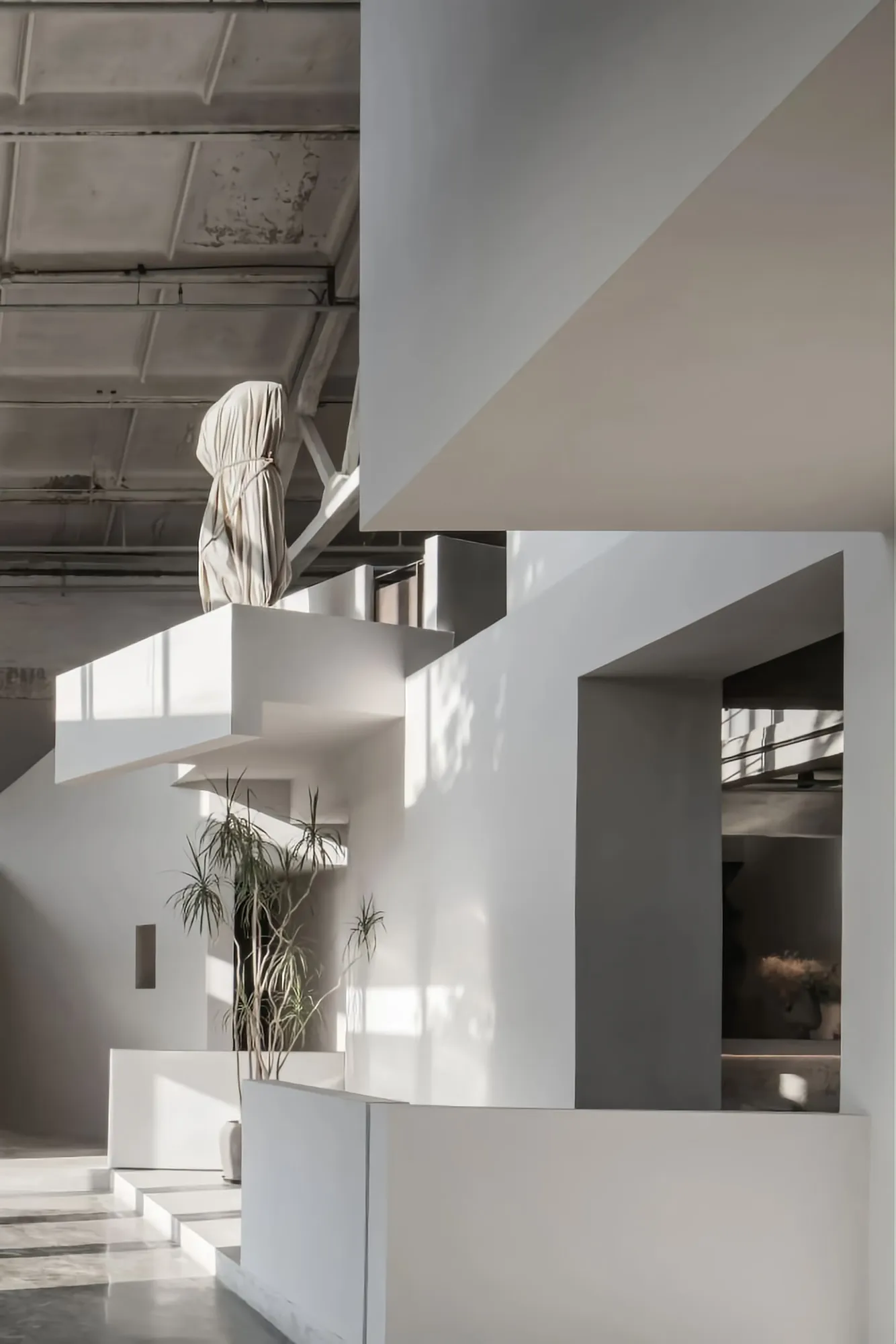 A minimalist white lobby interior with geometric design elements and natural light.