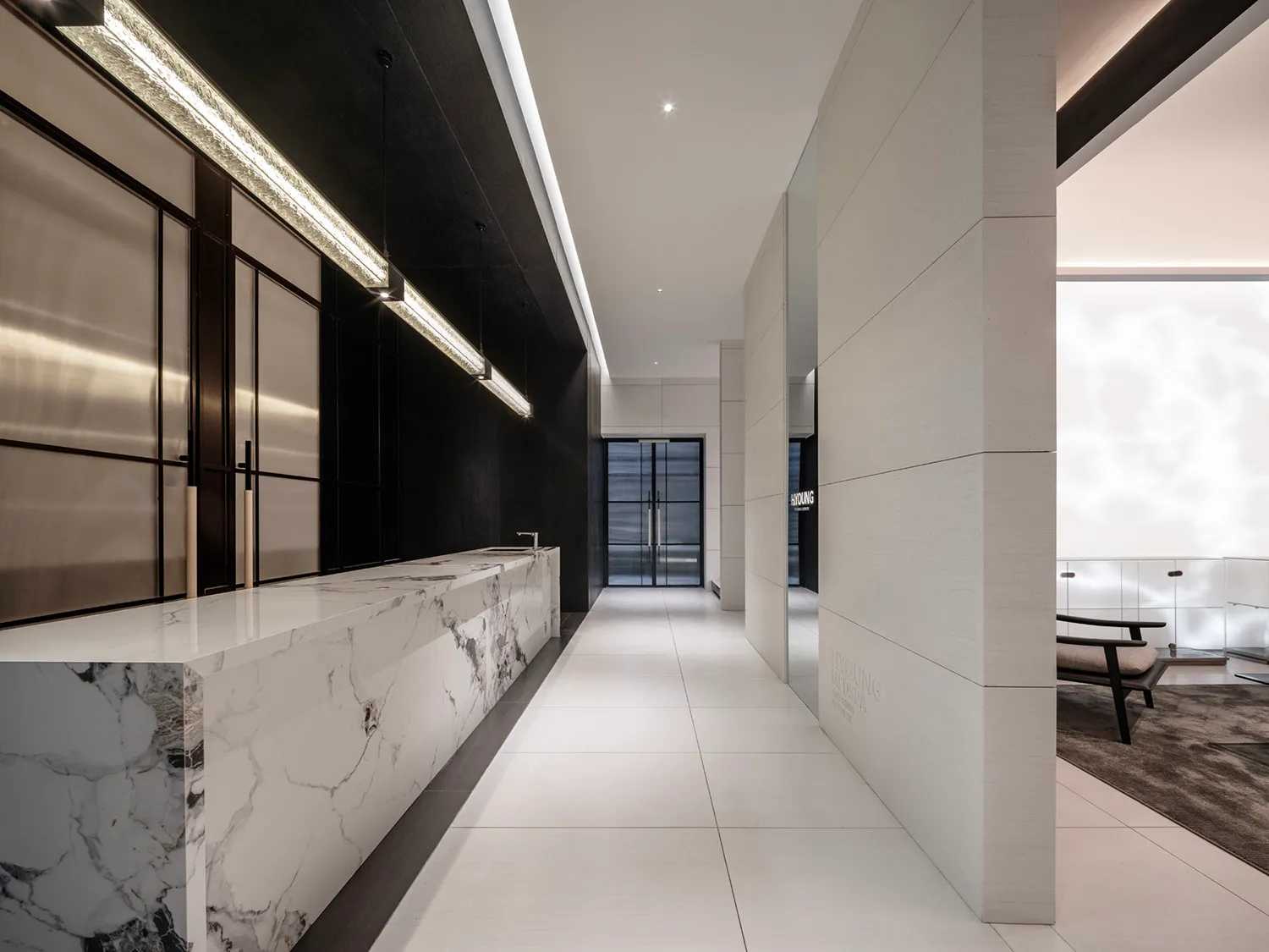 Modern spa reception area featuring a marble counter and concrete wall with a mirrored ceiling for a sleek, minimalist design