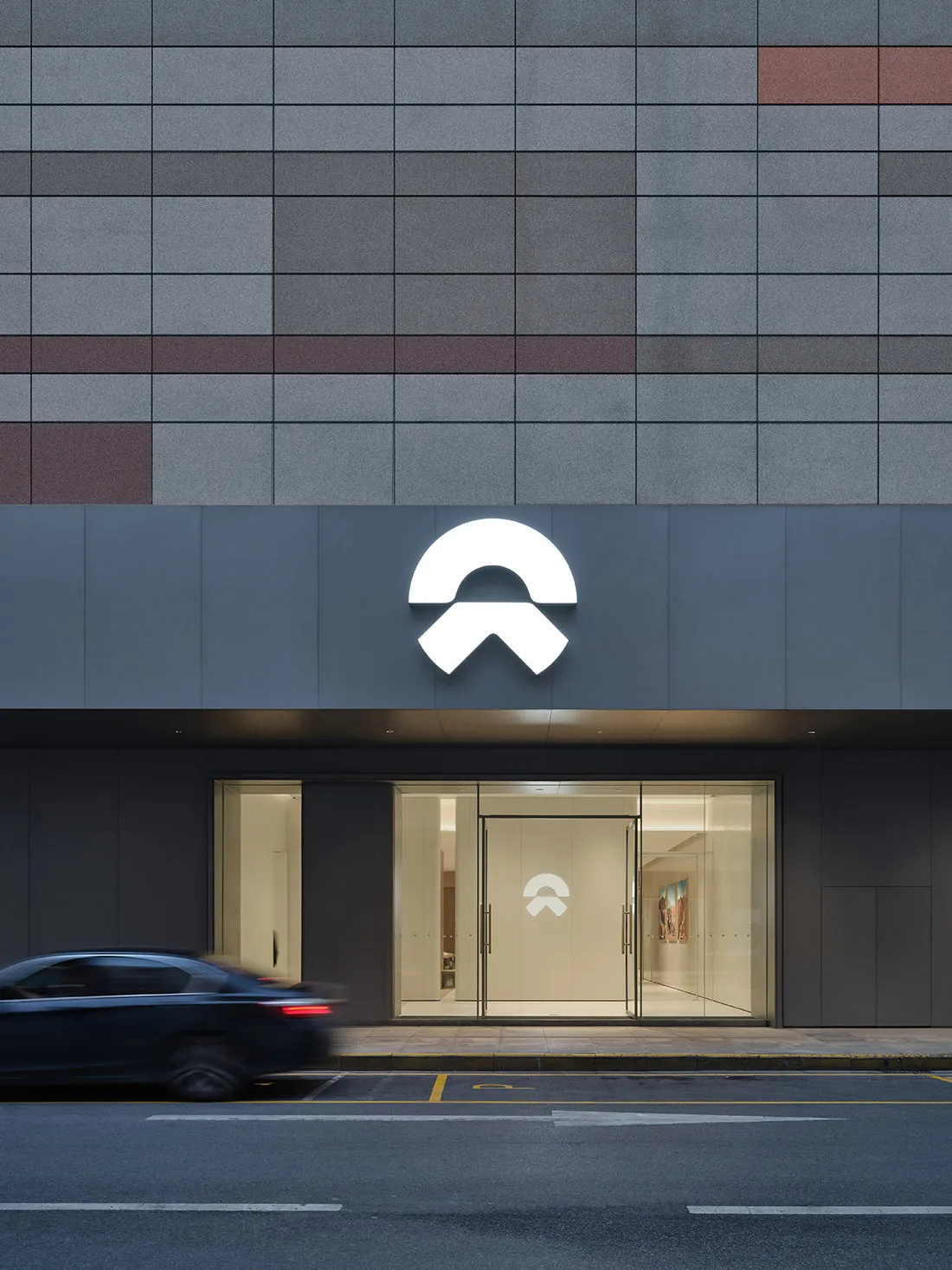 Modern storefront with a glass entrance, concrete facade, and metal elements.