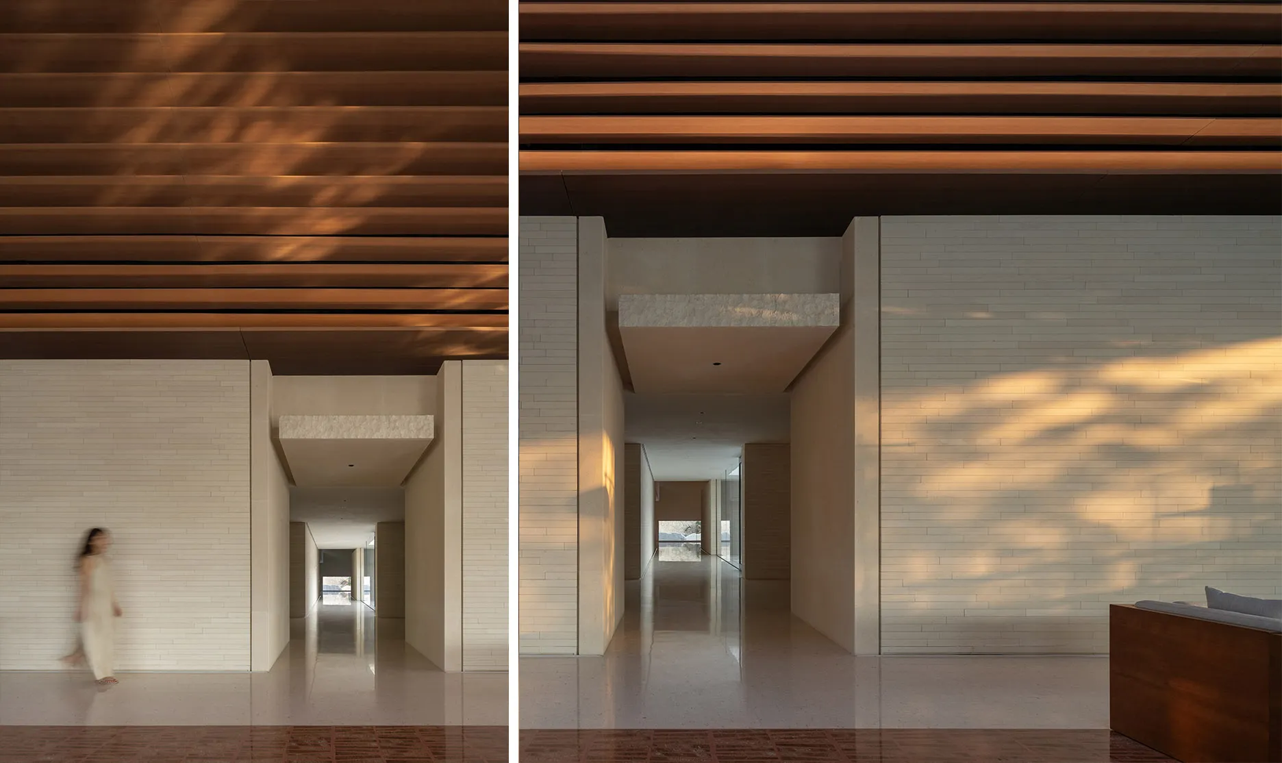A modern interior space featuring a stone wall with a hallway extending into the background, illuminated by natural light fil