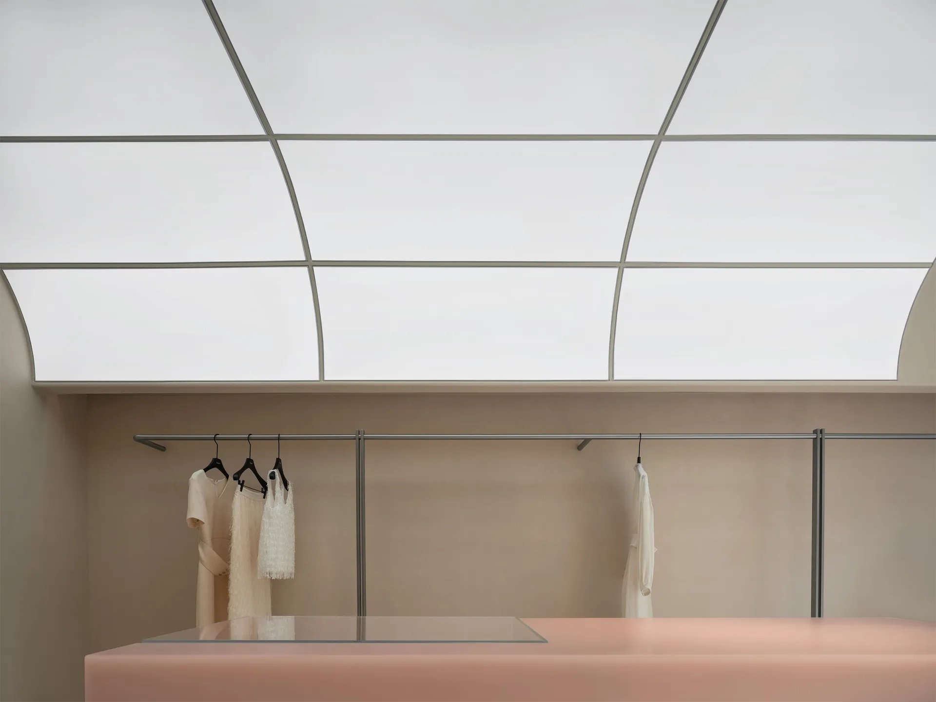 A modern minimalist fashion retail space features concrete and glass materials.