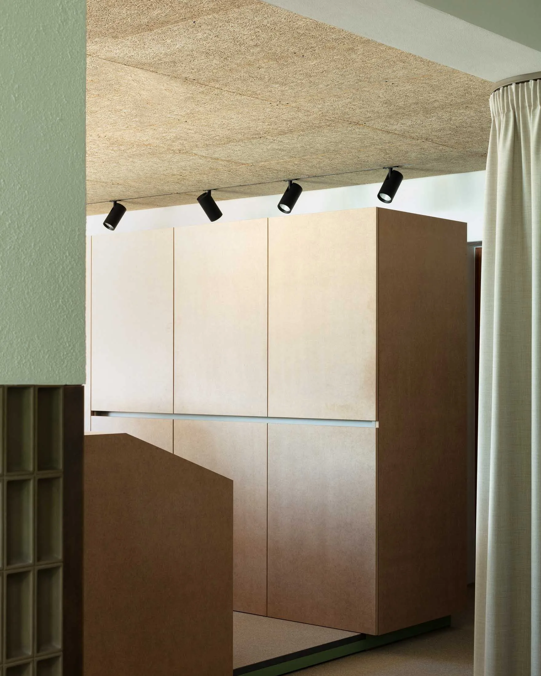 A minimalist living room cabinet made of wood, featuring sleek, clean lines and a simple design.