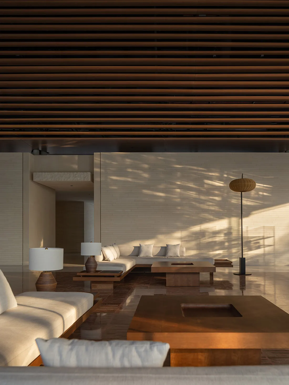 A modern minimalist living room with wood furniture and floor-to-ceiling windows.