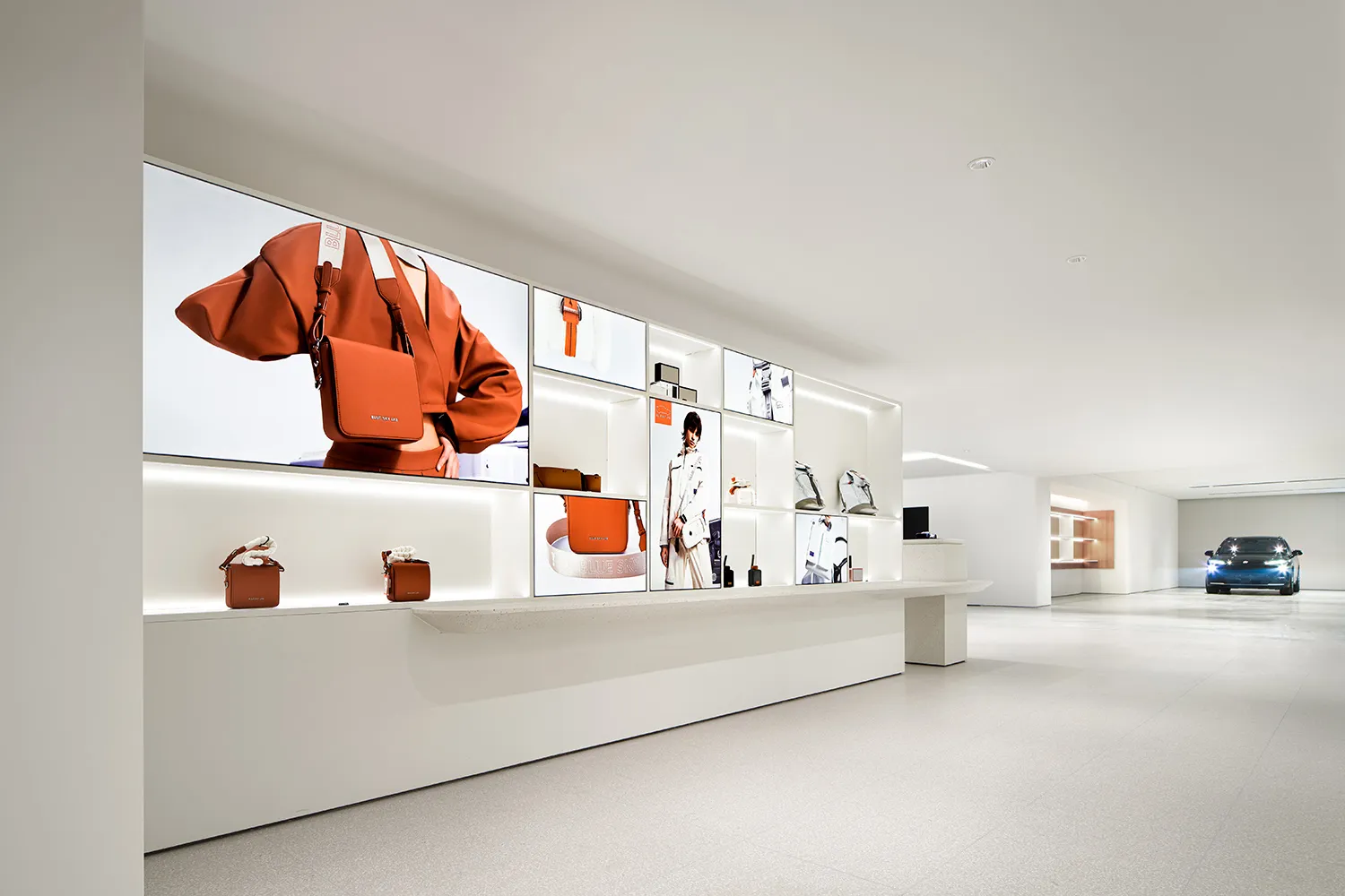 A modern retail storefront with a display wall showcasing bags and accessories.