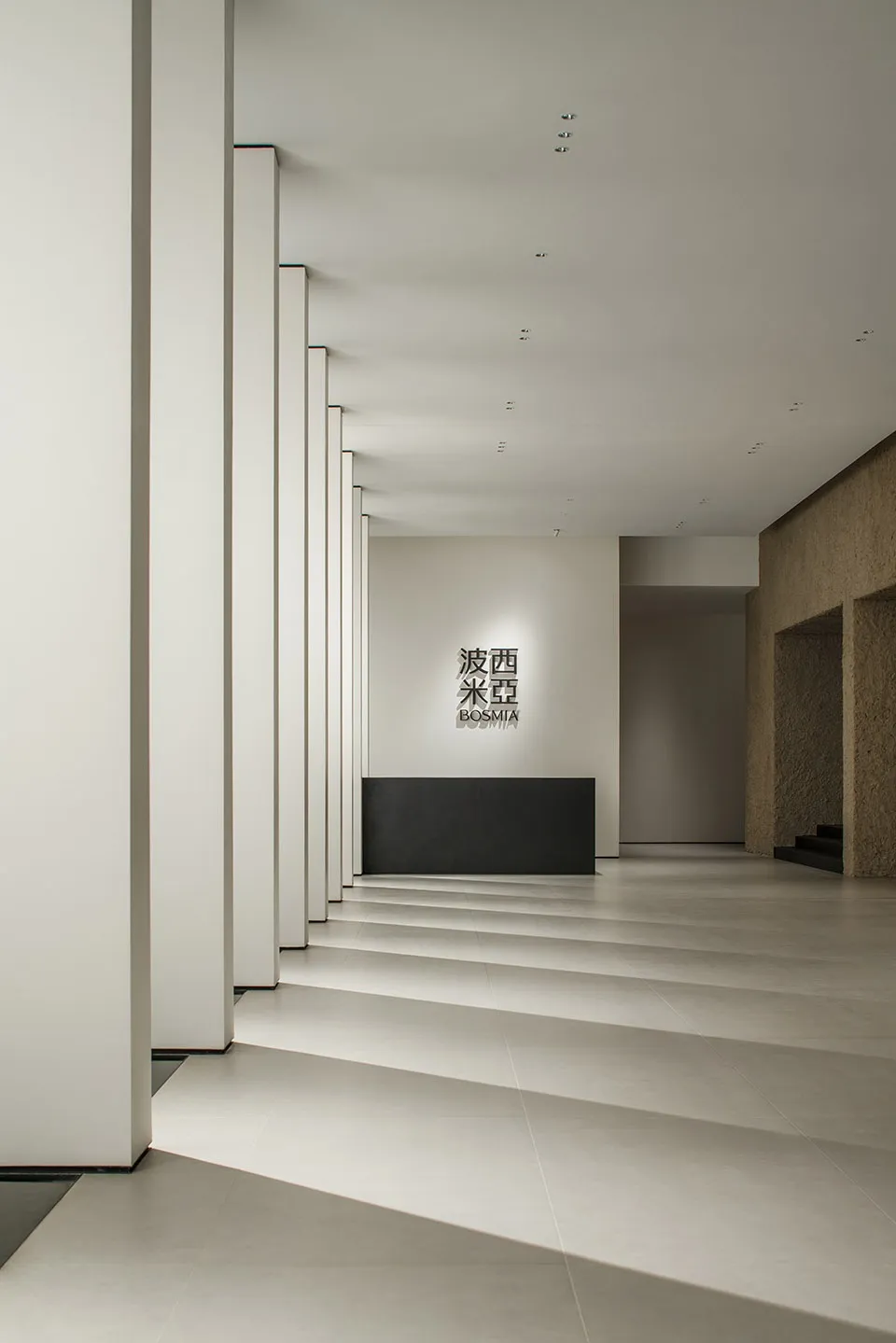 Modern minimalist lobby featuring concrete walls and flooring.