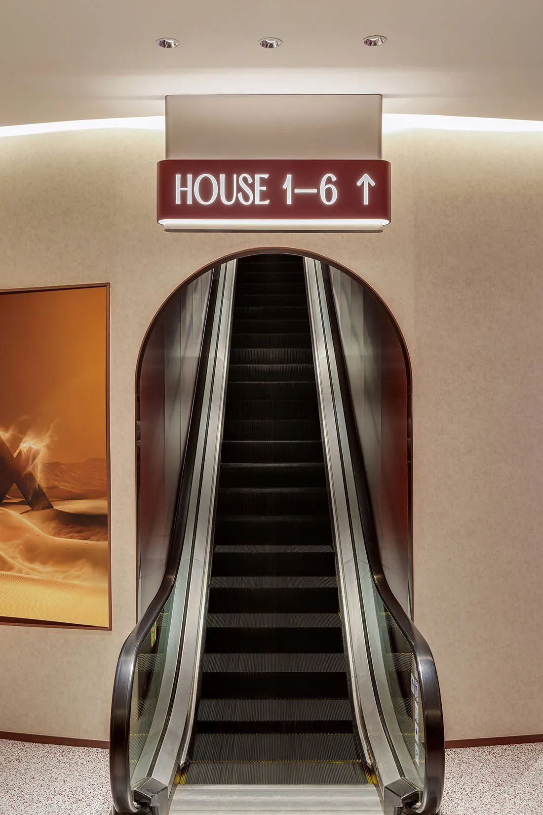 An illuminated escalator system with industrial lighting in a modern commercial interior.