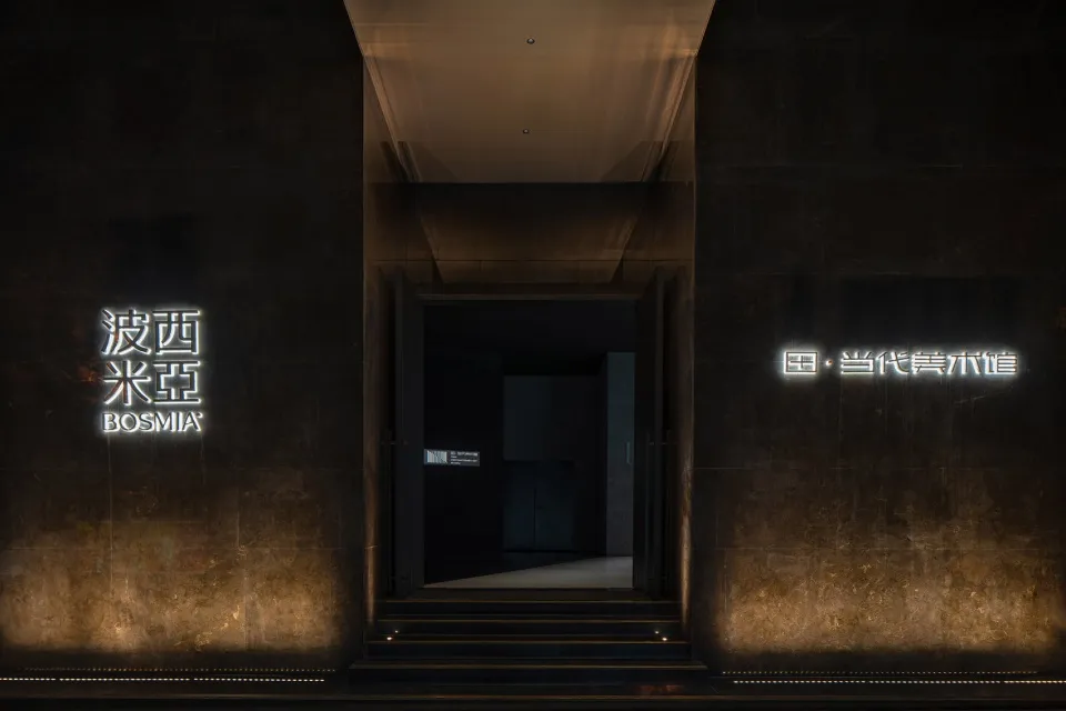 現代流線型桌燈置於黑暗極簡空間,搭配金屬元素與深色背景。