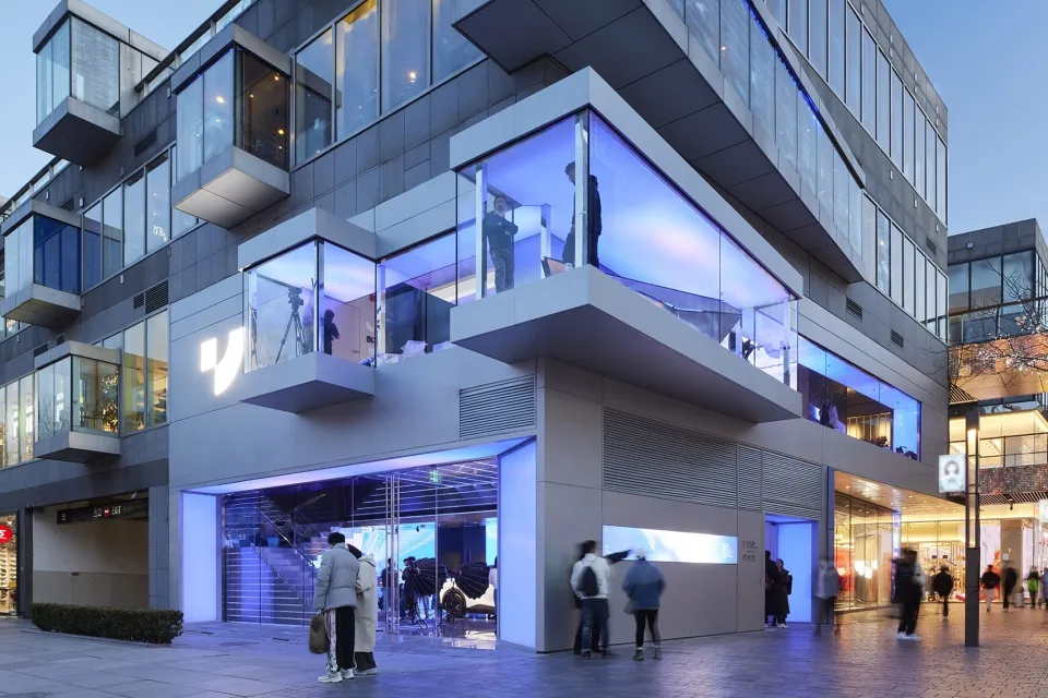 A modern retail storefront with large glass windows and illuminated interior.
