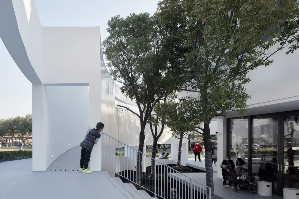Modern public space with glass walls and metallic railings.