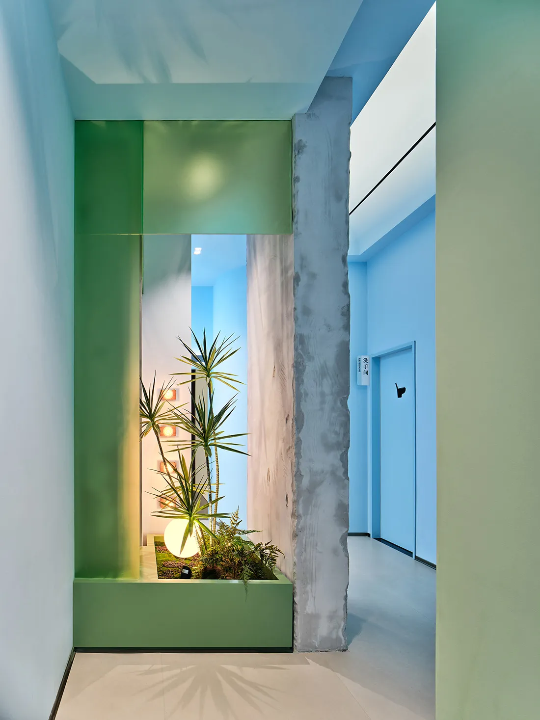 A minimalist interior design featuring a glass window with greenery inside a hallway.