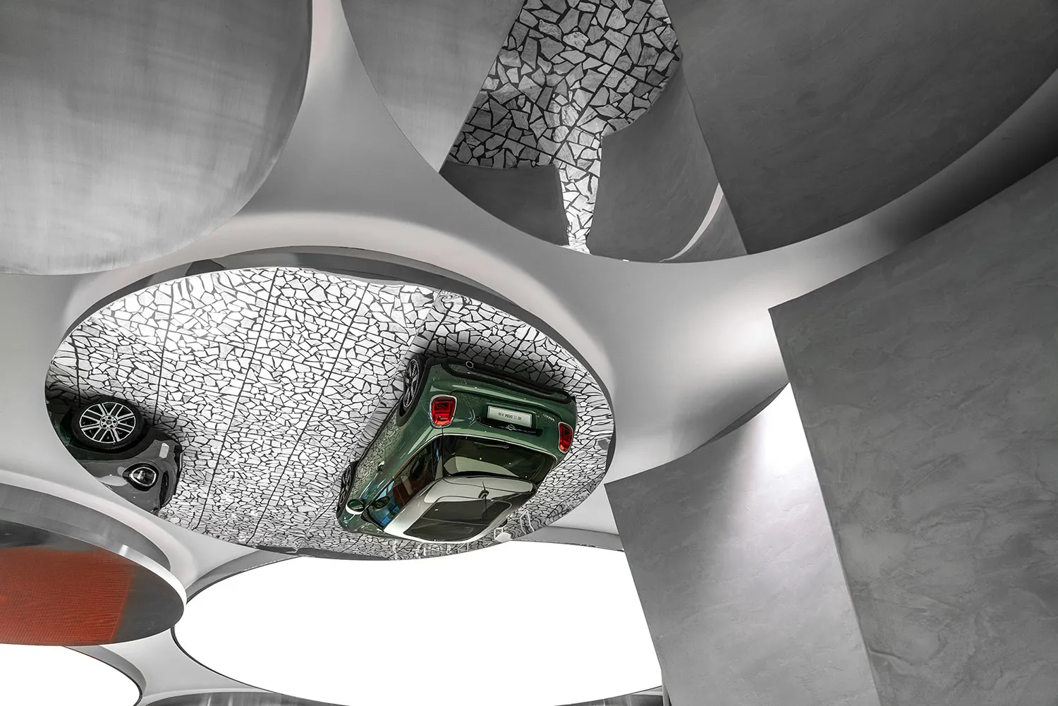 Modern car showroom ceiling design featuring a concrete structure and a green car on display.