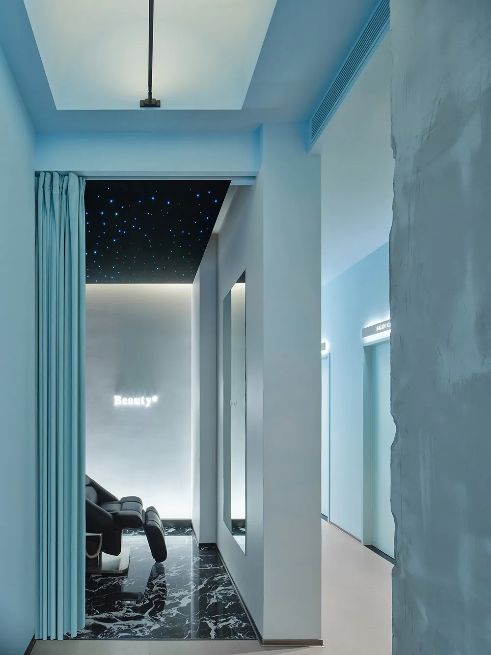 A modern spa suite featuring luxury marble flooring and sleek concrete walls.