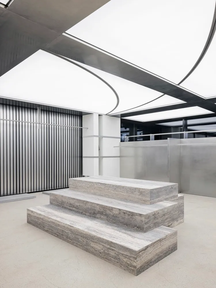 A modern industrial interior space featuring concrete steps and a minimalist design.