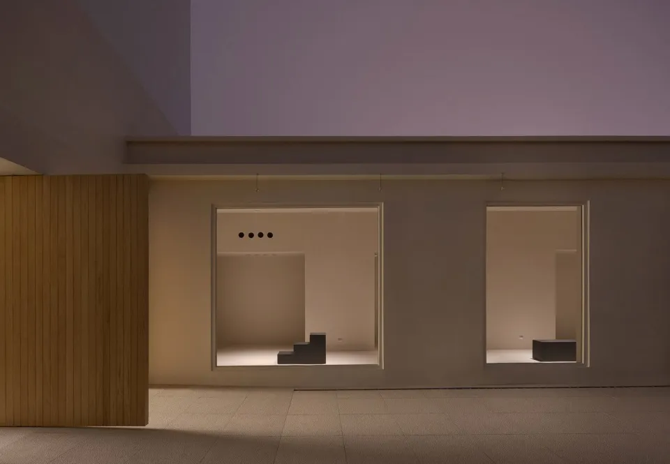 Minimalist interior space featuring wooden walls and concrete floors.
