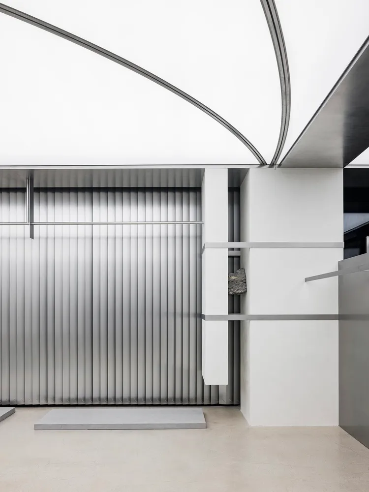 Modern minimalist interior with metallic surfaces and geometric design elements.