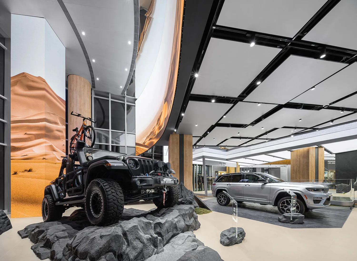 Jeep vehicles showcased in an industrial-themed showroom with concrete flooring and metal structures.