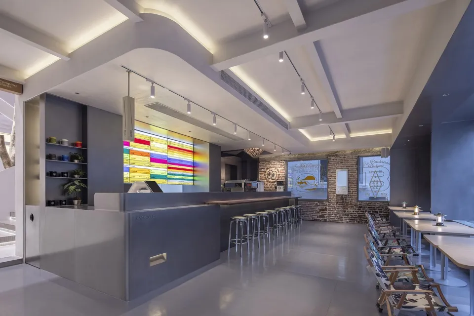 Modern restaurant interior with concrete, glass, and metal elements.