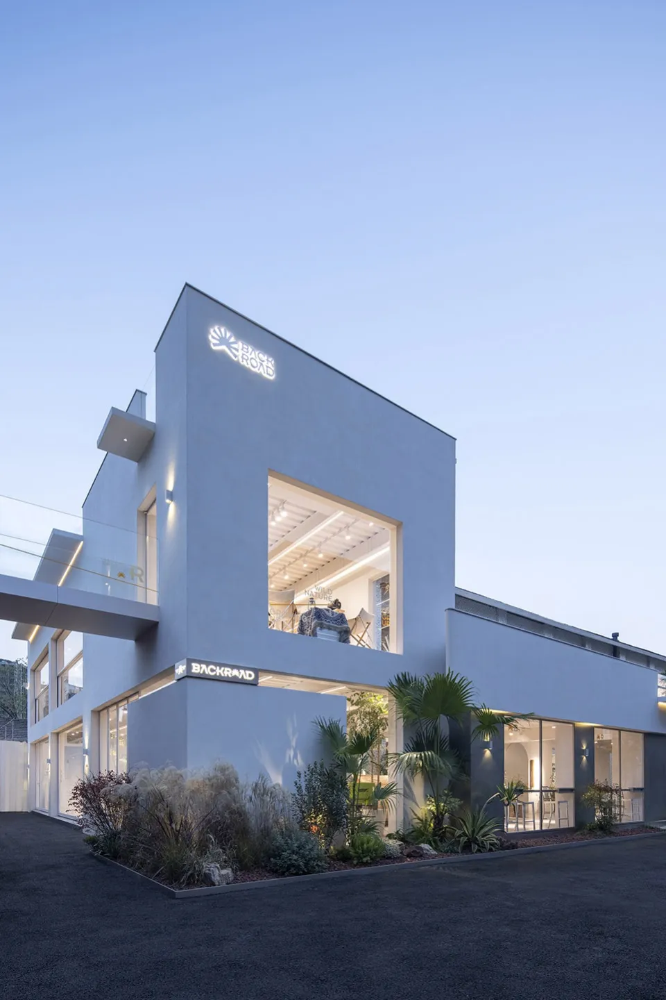 Modern storefront with a glass facade and concrete structure, showcasing stylish retail interiors.