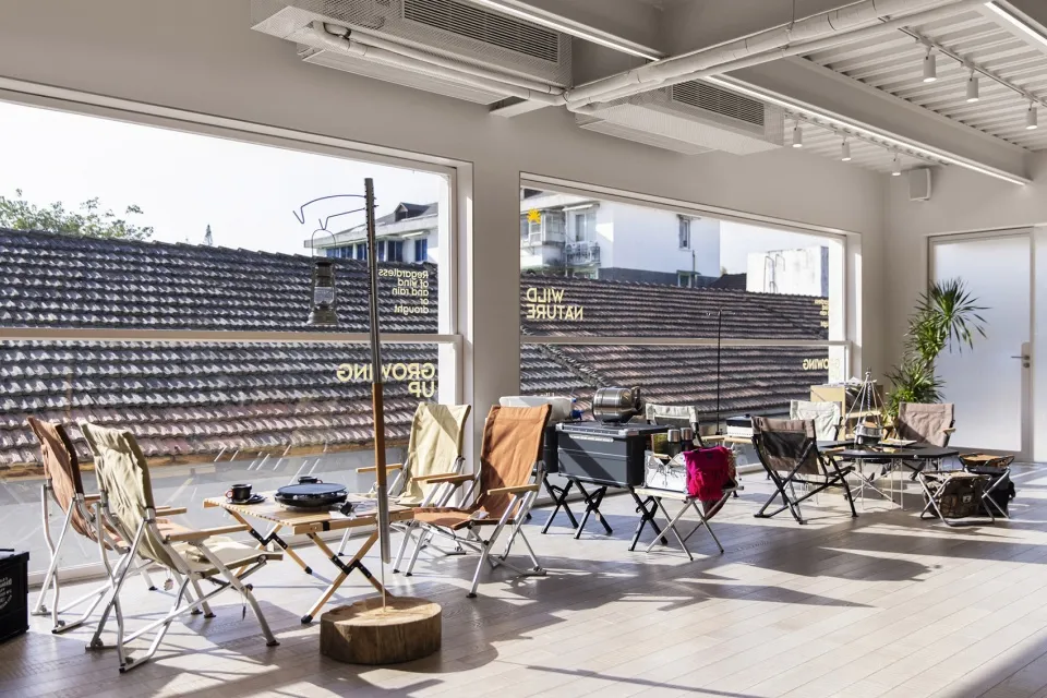 Modern, foldable chairs arranged on a wooden platform with outdoor elements in the background.
