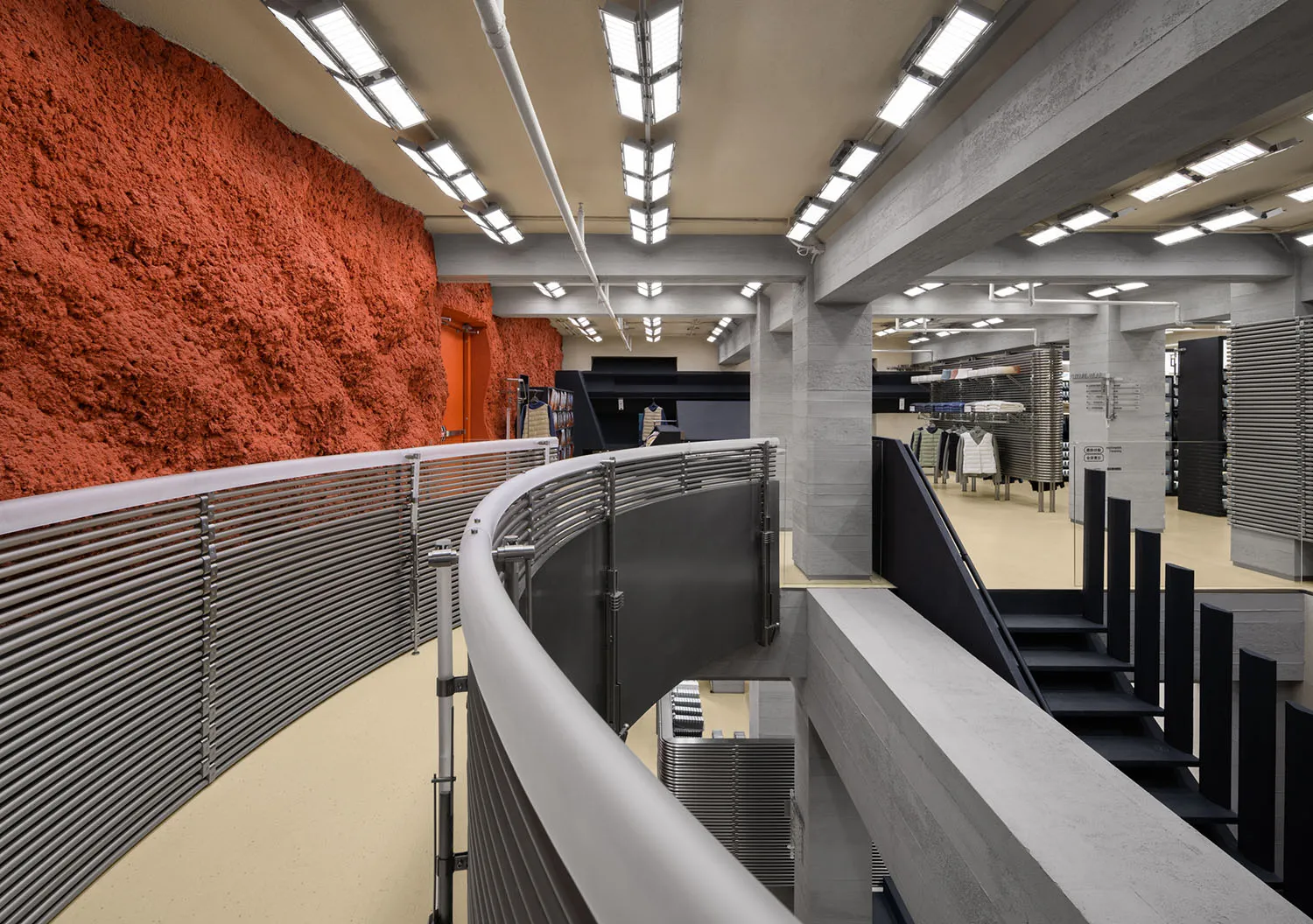 A modern retail store interior featuring concrete, metal, and textile materials.