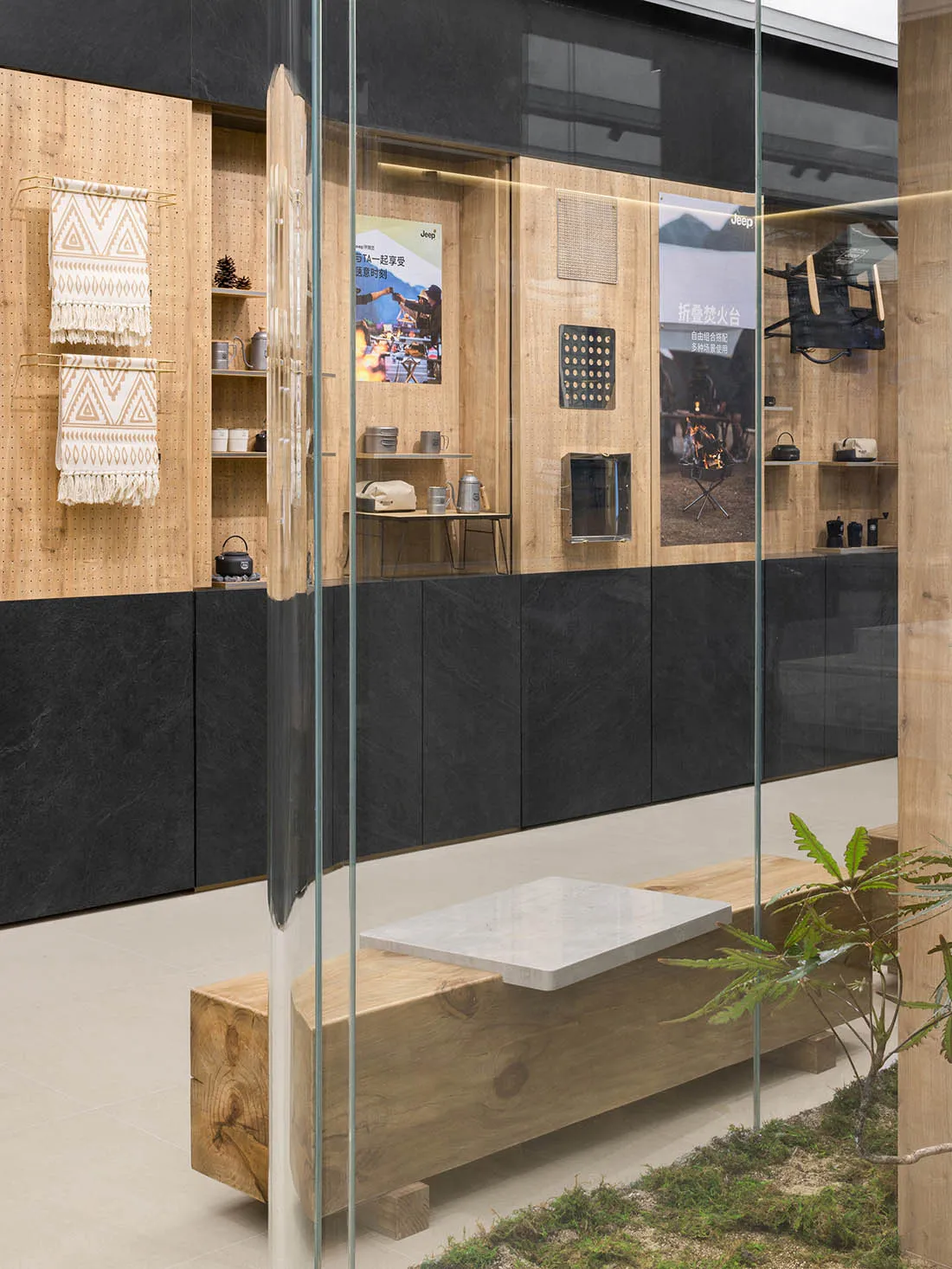 Modern retail storefront with wooden shelves, glass display cases, and a cozy seating area with cushioned stools and a plant.